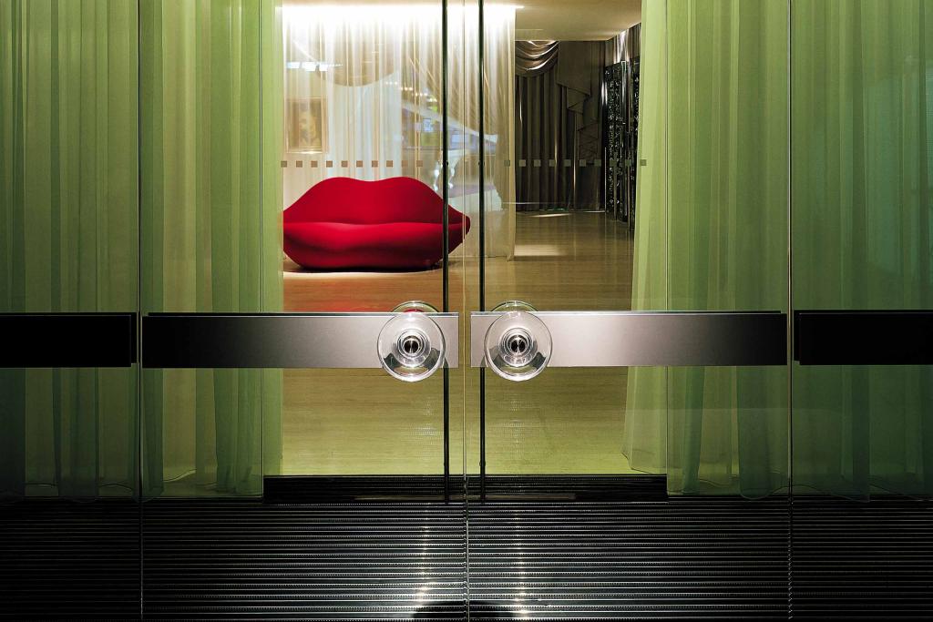 The door to the Sanderson hotel looks into the lobby showcasing a red lip shape sofa.