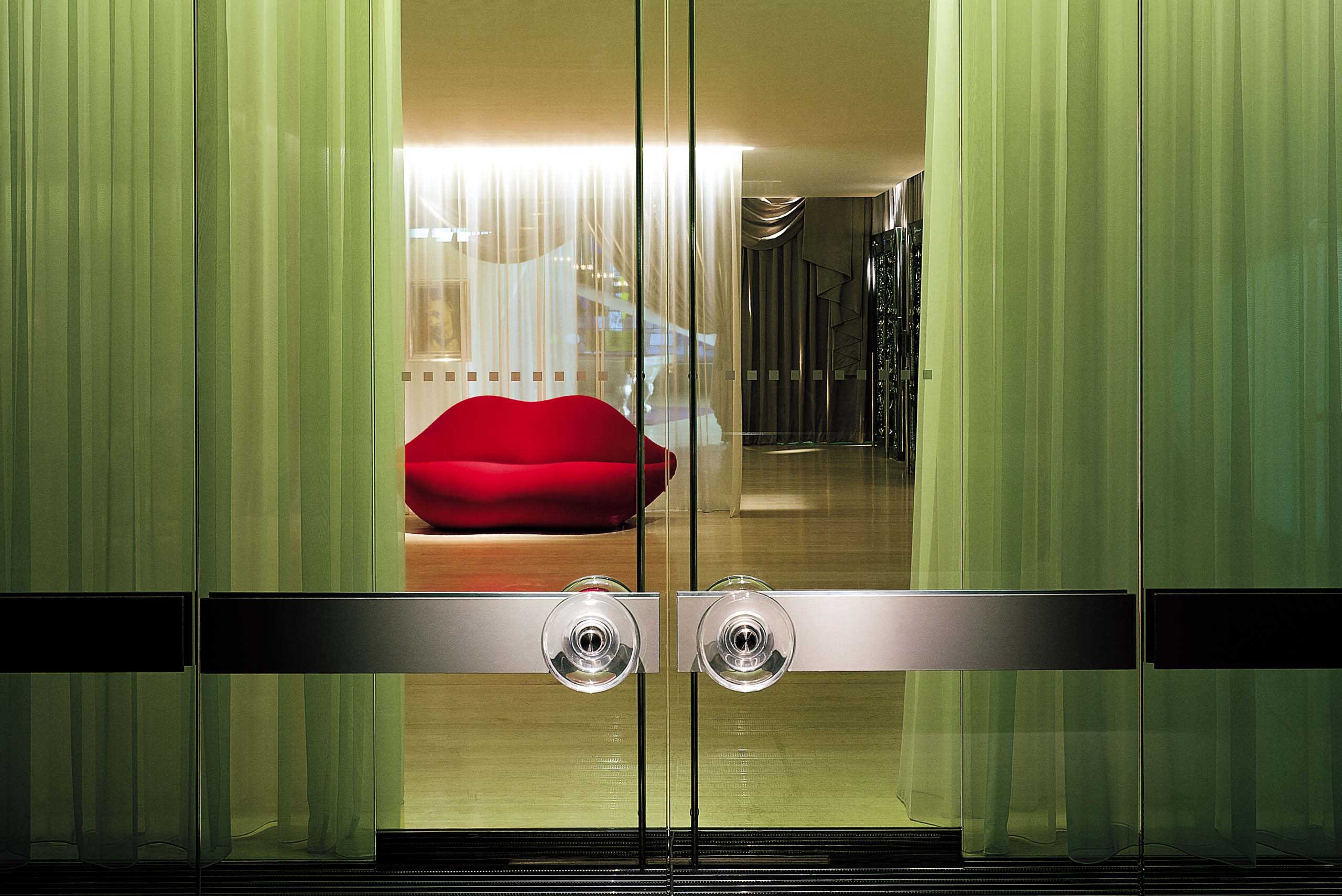 The door to the Sanderson hotel looks into the lobby showcasing a red lip shape sofa.