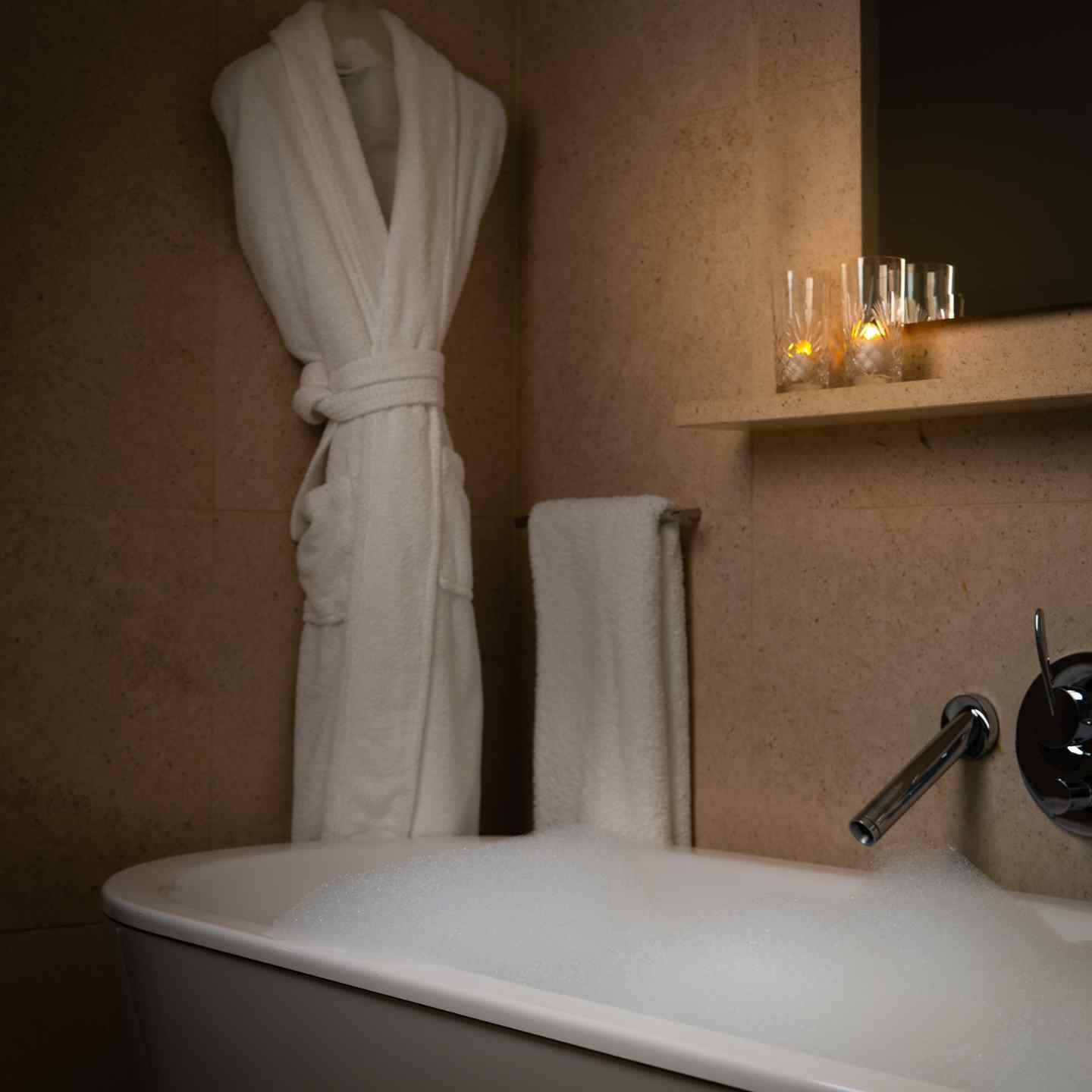 Free standing bathtub, robe, towel, and candles in St Martins Lane bathroom