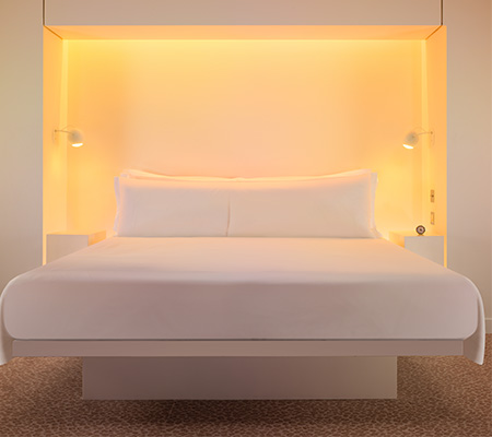 White bed with orange yellow LED lights framing the bed