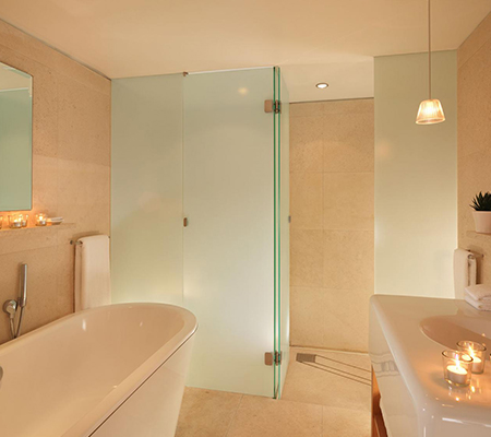 Bathroom with large white bathtub and glass shower walls