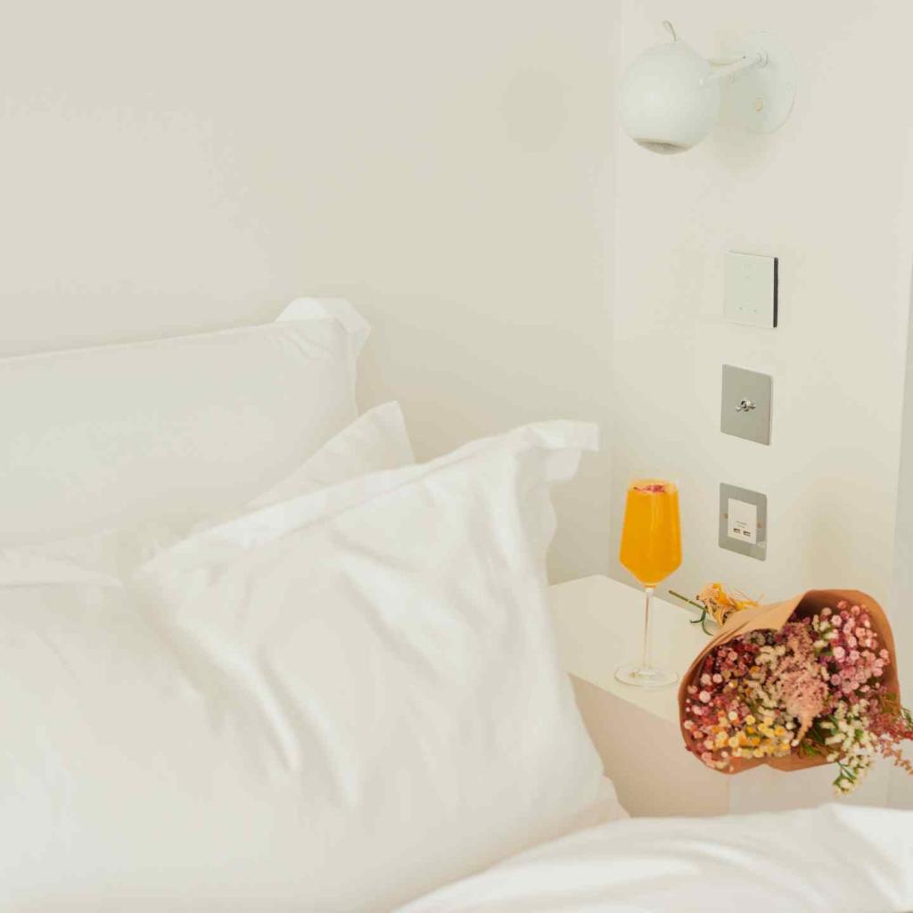 Flowers sit beside a bed
