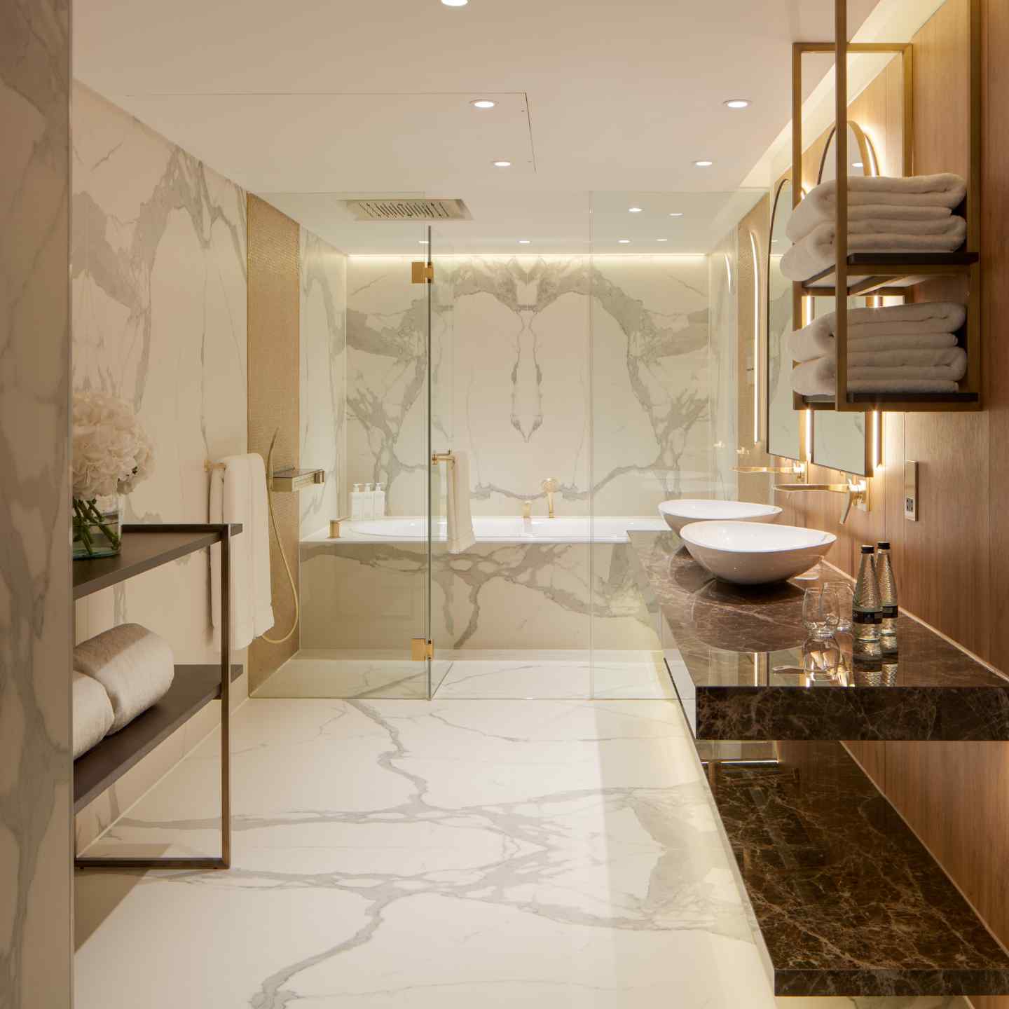 A large marbled bathroom with walk in shower and double sinks