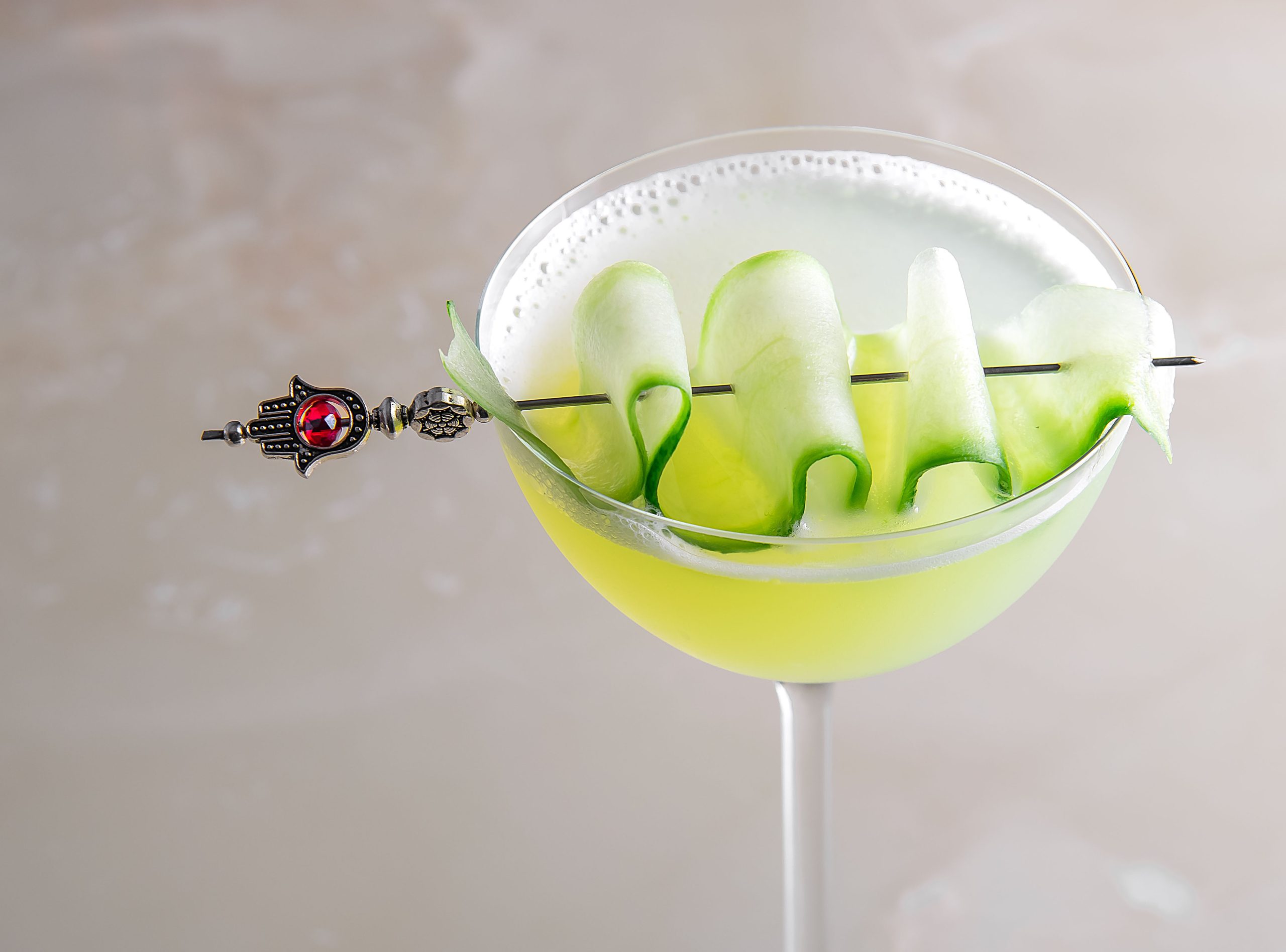 Close up image of cucumber cocktail in a stemmed glass