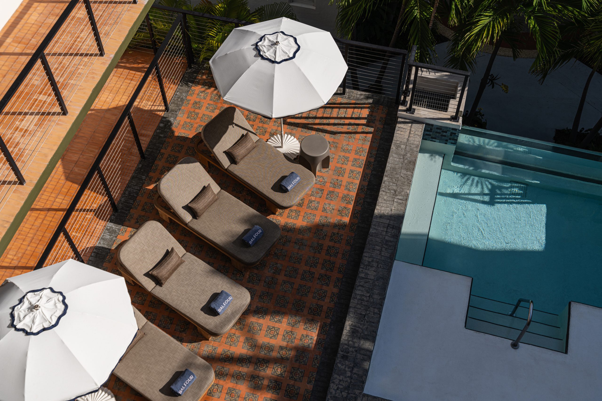 Sun deck with loungers and umbrellas next to a refreshing pool at a South Beach Miami boutique hotel