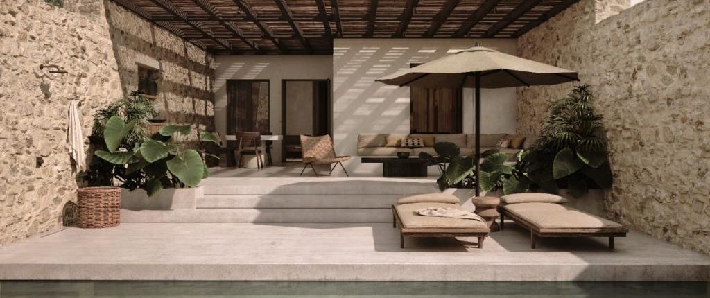 Luura suite with two sunbeds outside in front of a pool